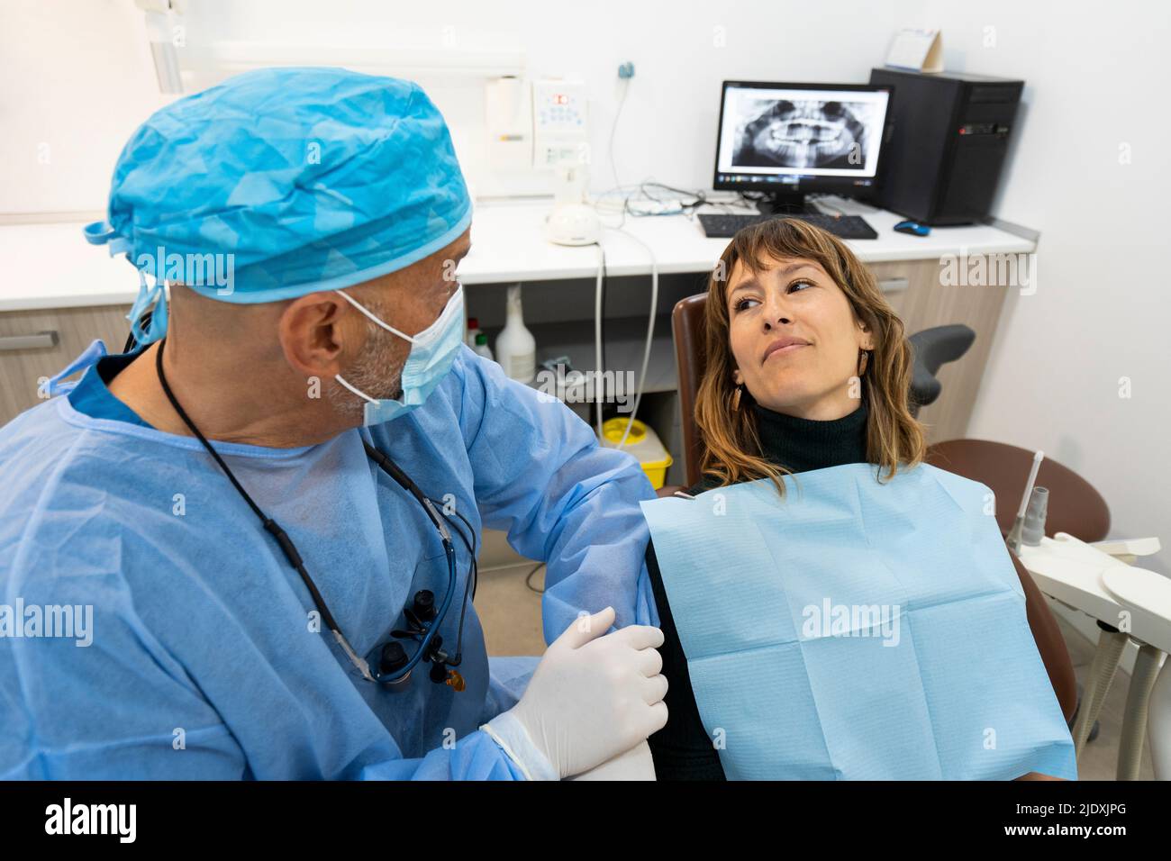 Dentist talking with patient on chair at clinic Stock Photo Alamy