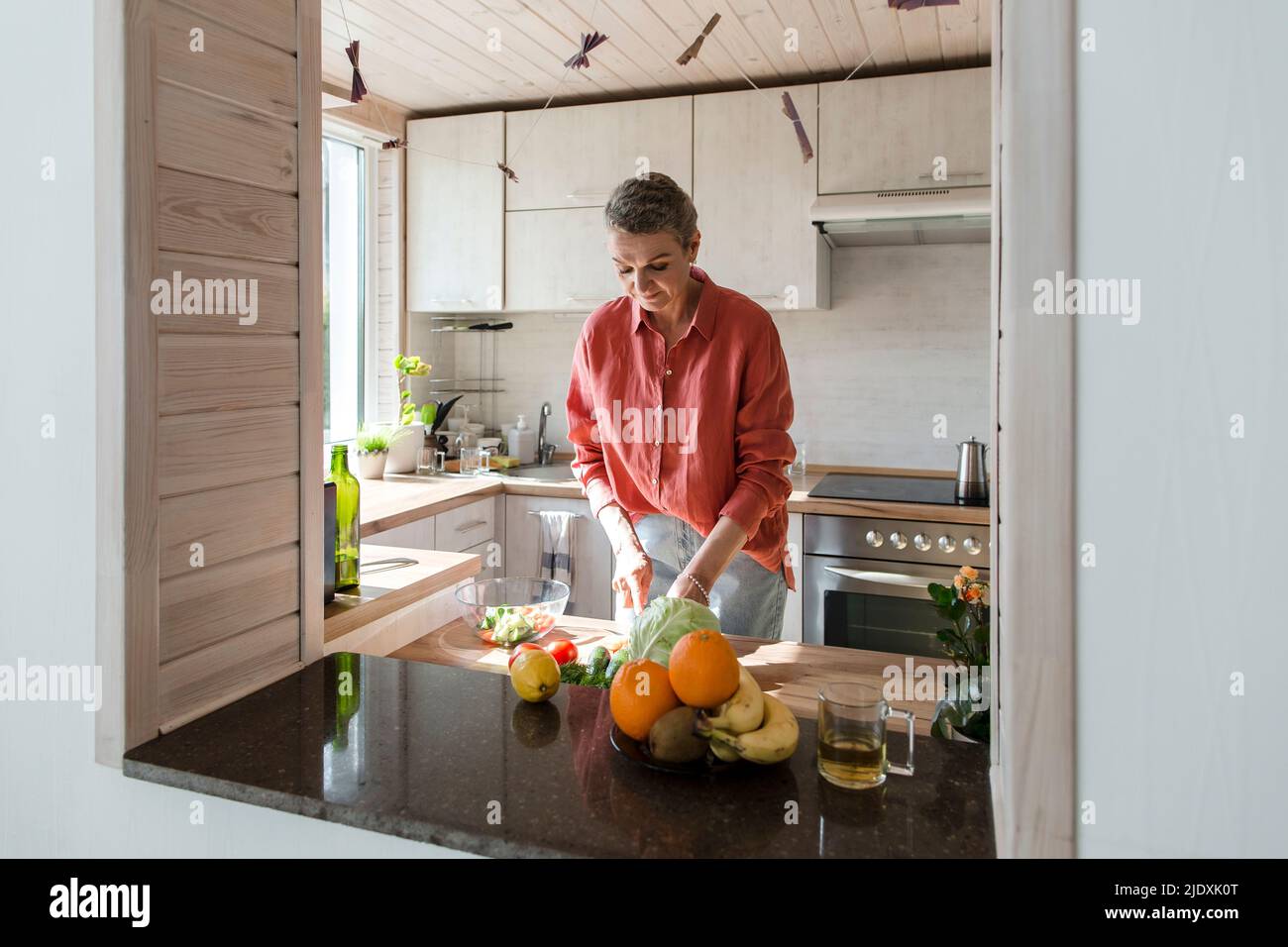 Woman preparing salad in kitchen at home Stock Photo