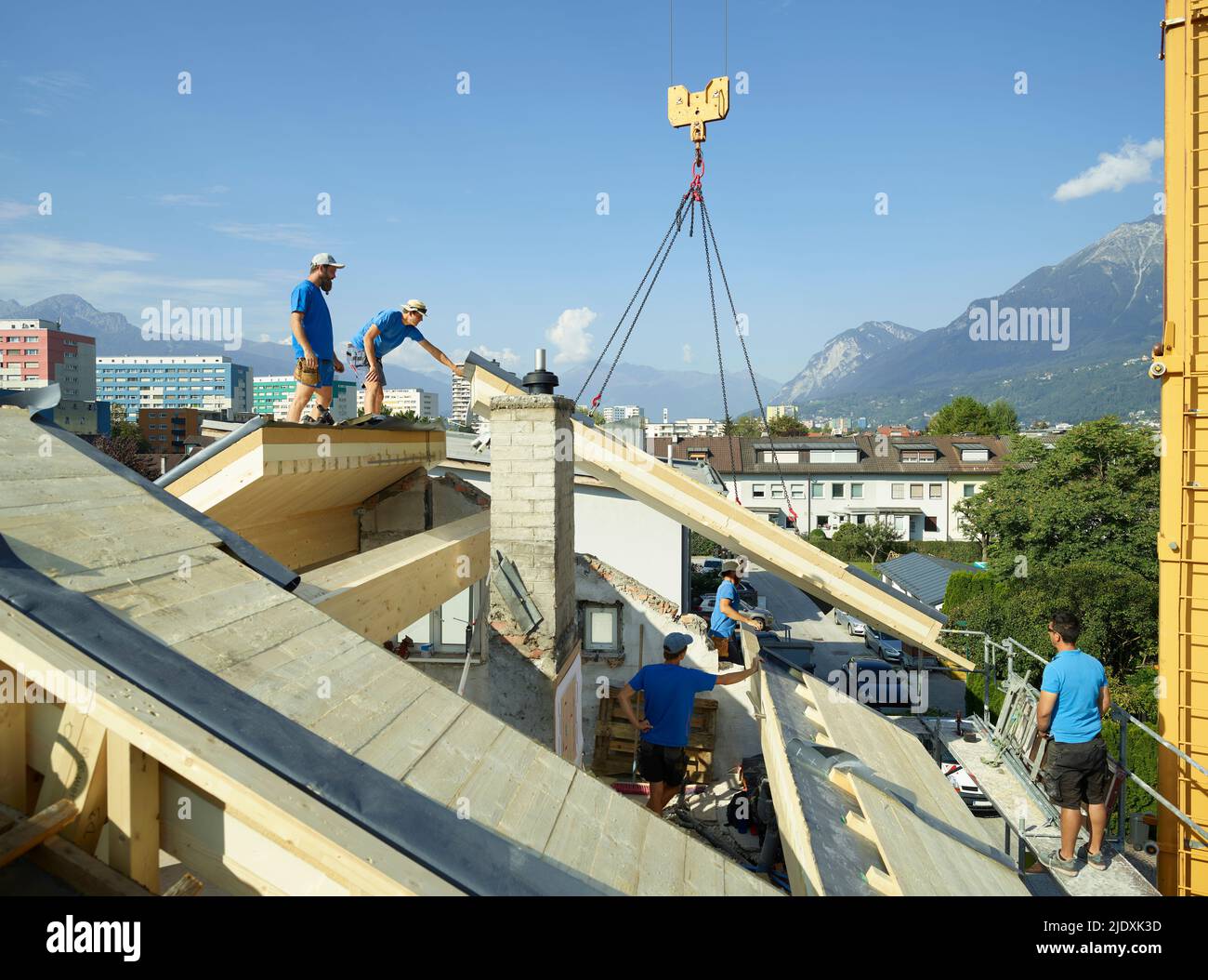 Bluecollar workers at construction site standing on rooftop Stock