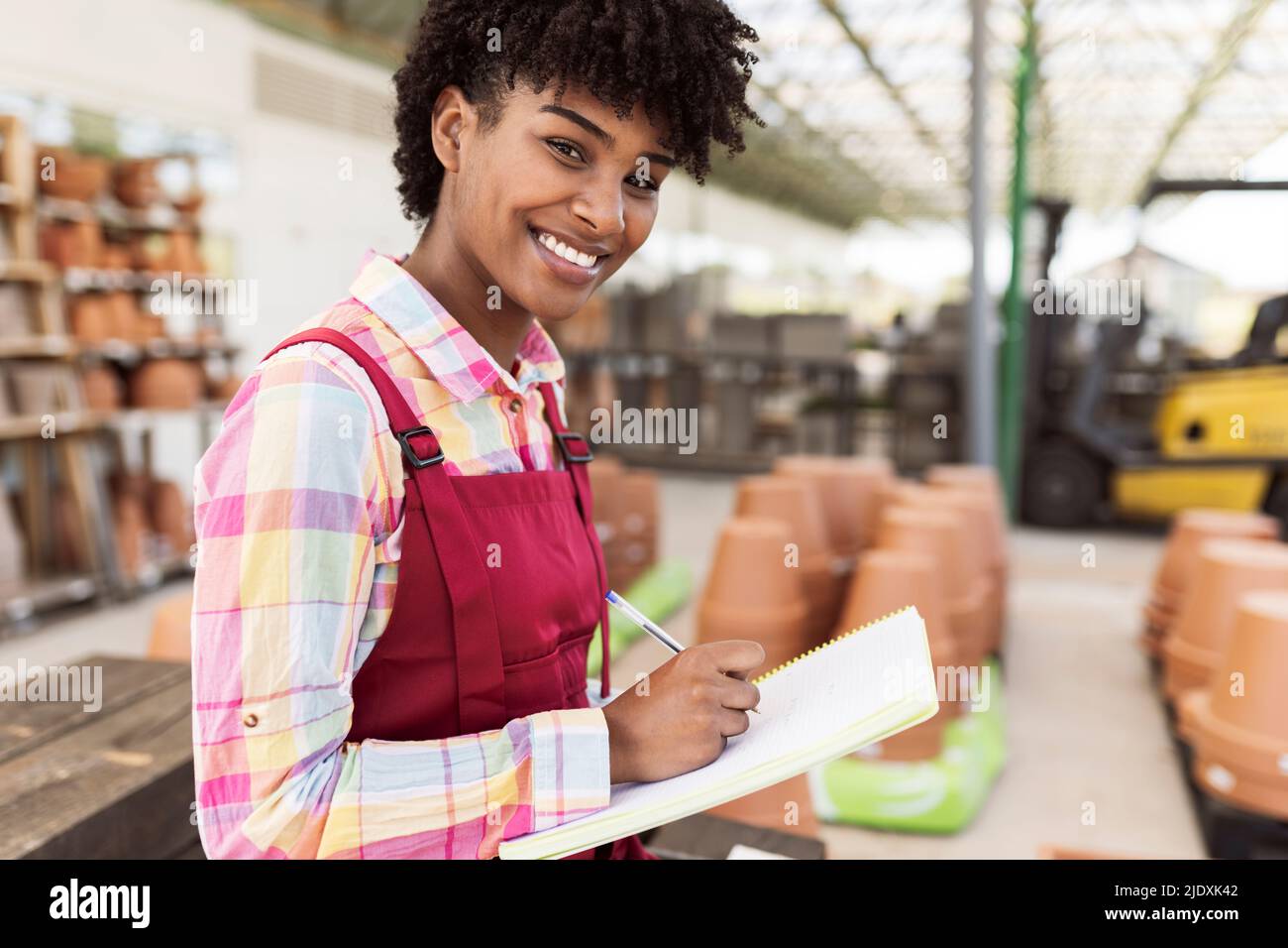 Smiling gardener preparing inventory at warehouse Stock Photo Alamy