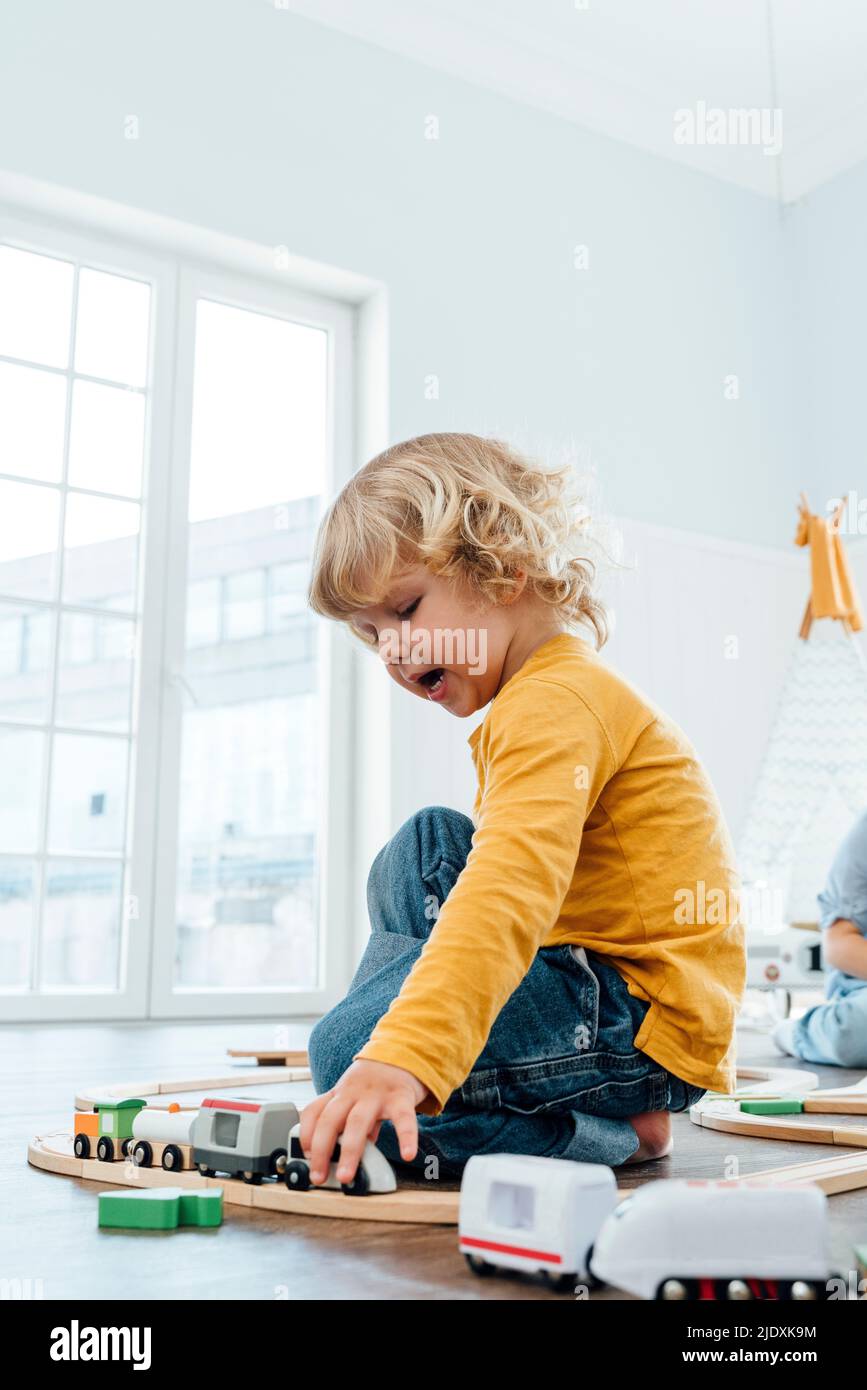 Boy playing with toy train at home Stock Photo Alamy