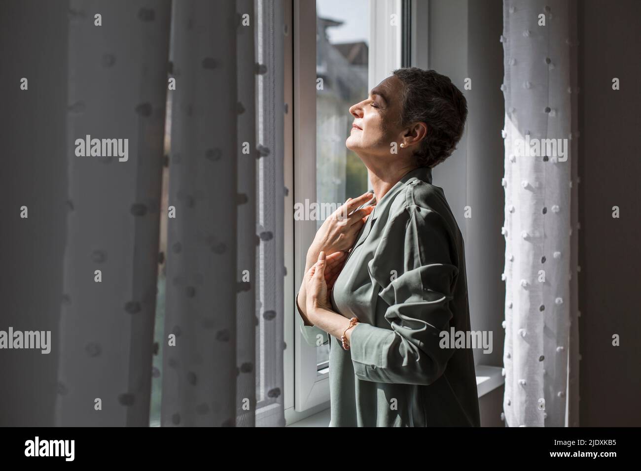 Mature woman with short grey hair at home Stock Photo
