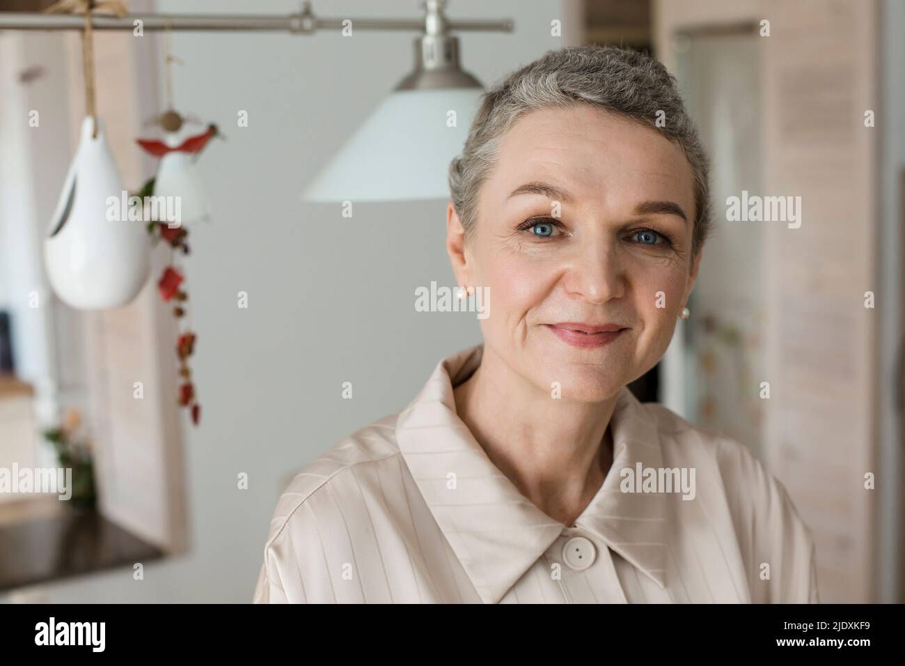 Portrait of confident mature woman with short grey hair at home Stock Photo