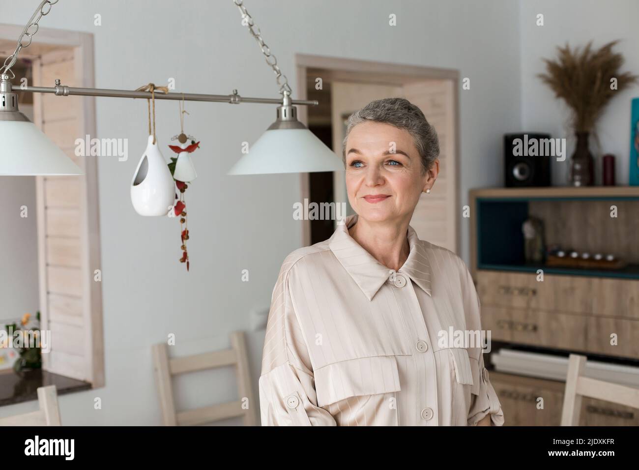 Confident mature woman with short grey hair at home Stock Photo