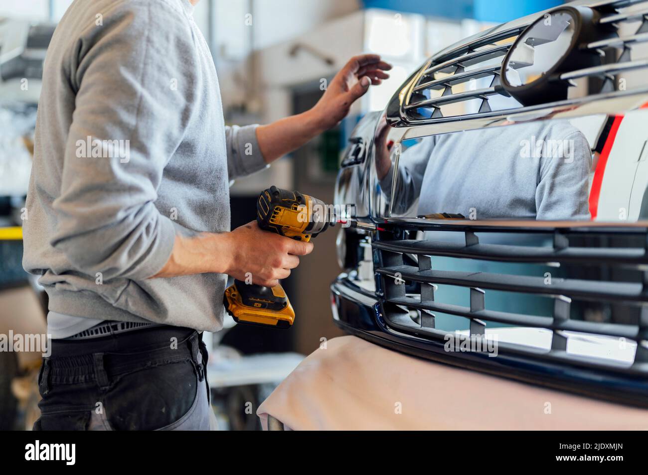 Auto mechanic holding power tool working in workshop Stock Photo