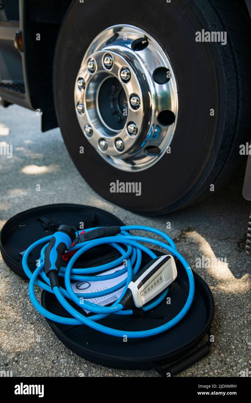 Electric battery charger by wheel of electric truck Stock Photo