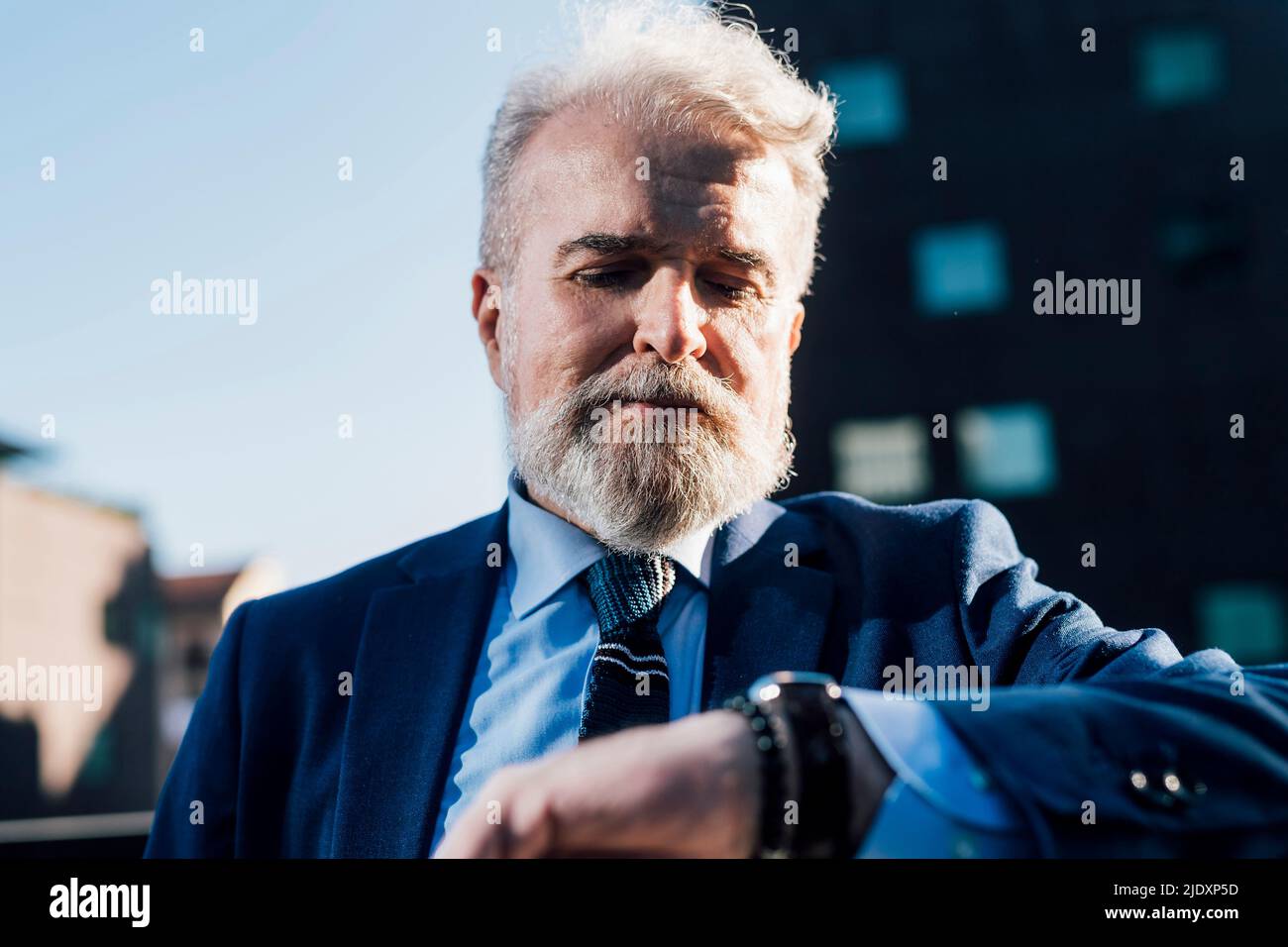Senior businessman checking notification on smart watch Stock Photo
