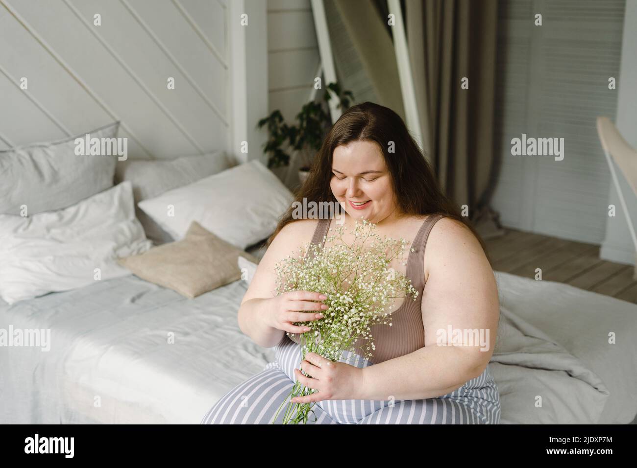 brunette woman with natural makeup and plus size body wearing