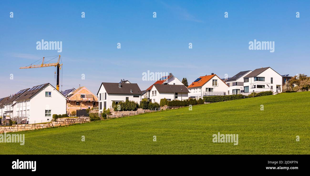 Germany, Baden-Wurttemberg, Waiblingen, Modern houses in new development area with industrial crane in background Stock Photo