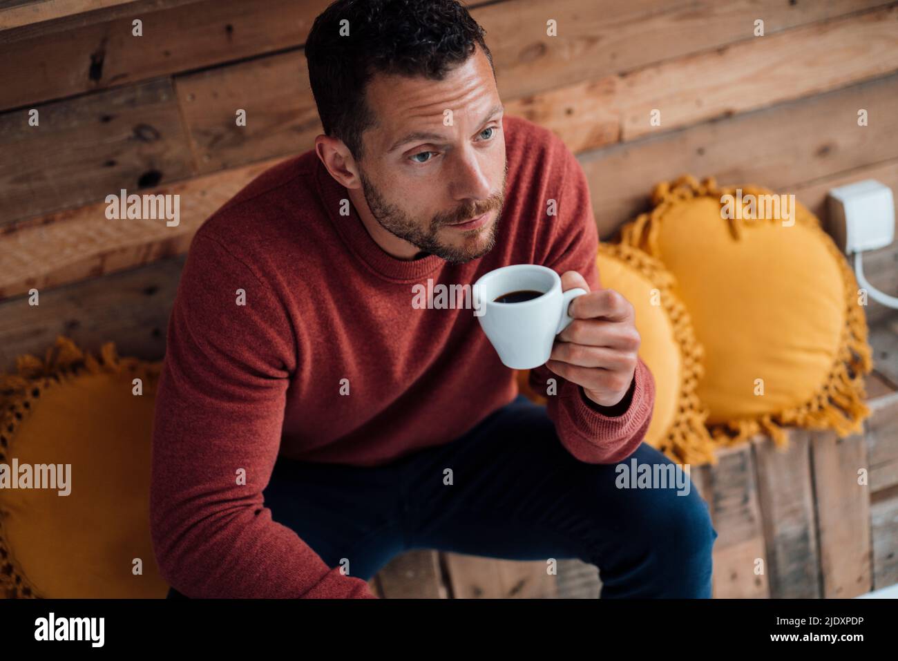 Man having coffee sitting on bench Stock Photo