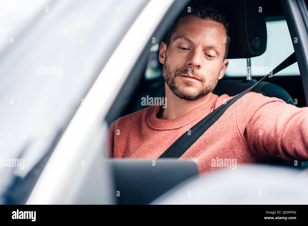 Man using laptop sitting in car Stock Photo