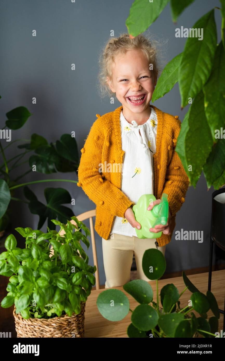 Girl laughing with spray bottle in living room Stock Photo Alamy