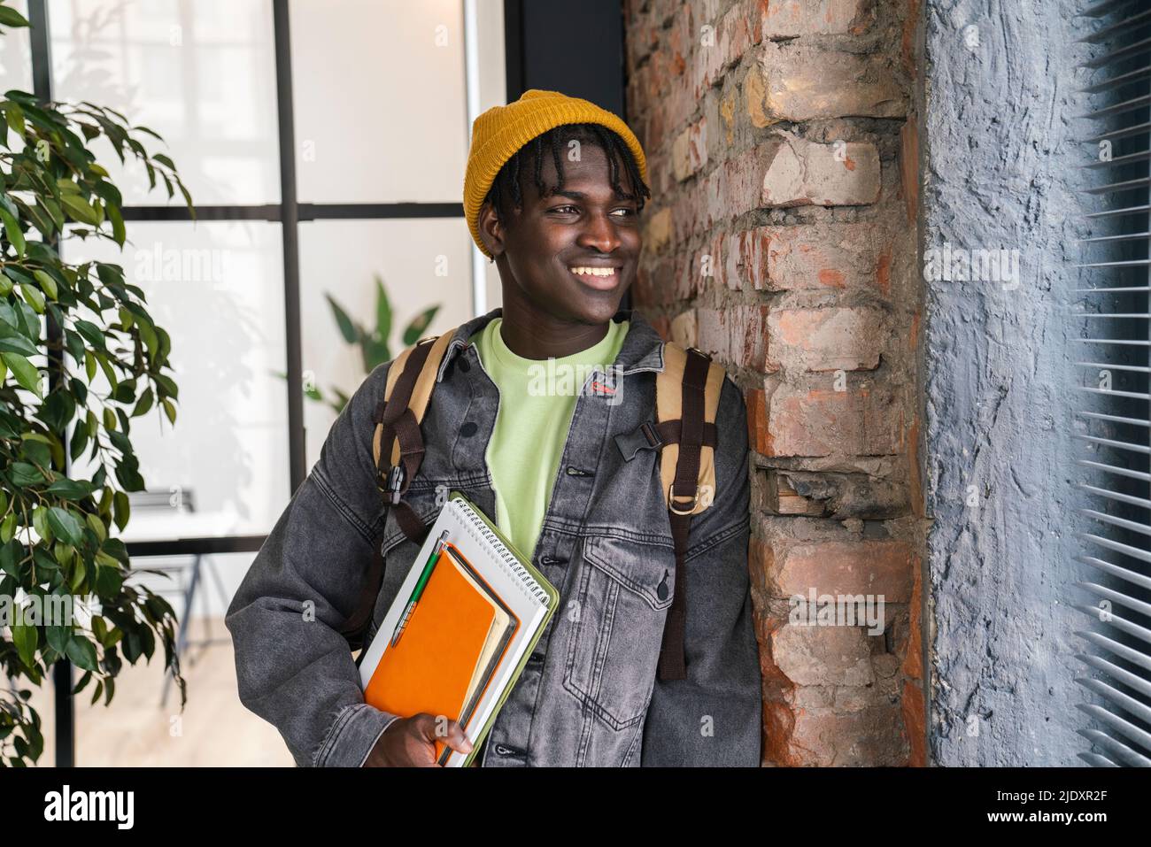 Smiling student looking through window at home Stock Photo