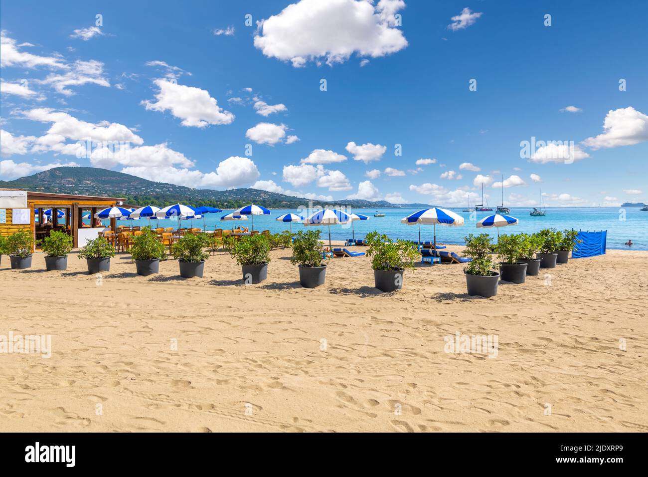 Chairs, lounges and umbrellas along the French Riviera at the sandy beach of Port Grimaud, France, near Saint-Tropez along the Mediterranean Sea. Stock Photo