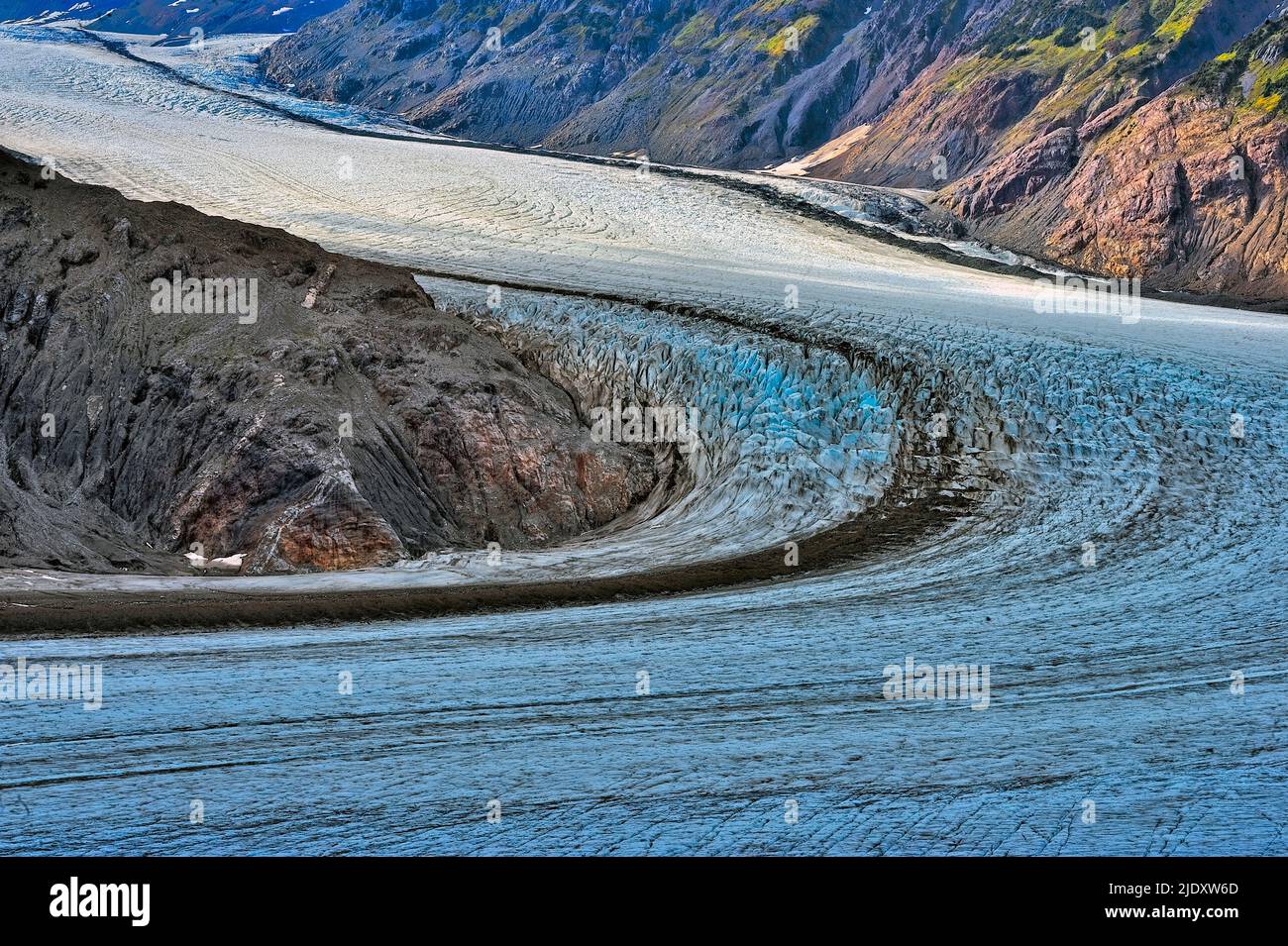 The mighty Salmon Glacier in northern British Columbia snakes around a corner high on a mountain side. Stock Photo