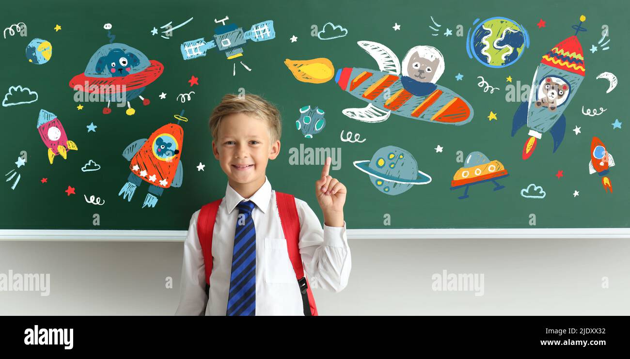 Little schoolboy near blackboard with drawn space Stock Photo - Alamy