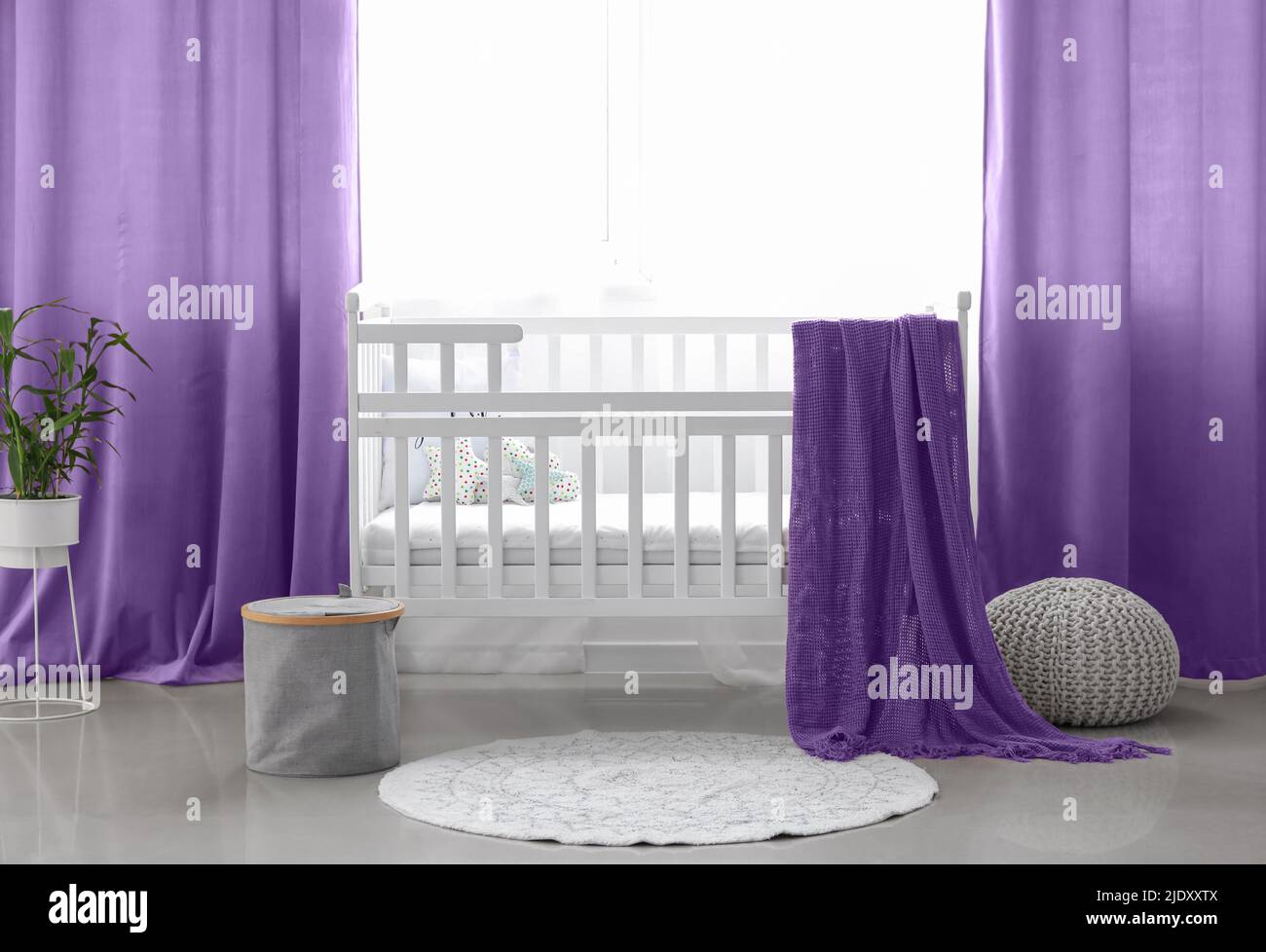 Interior of stylish children's room with comfortable crib near window