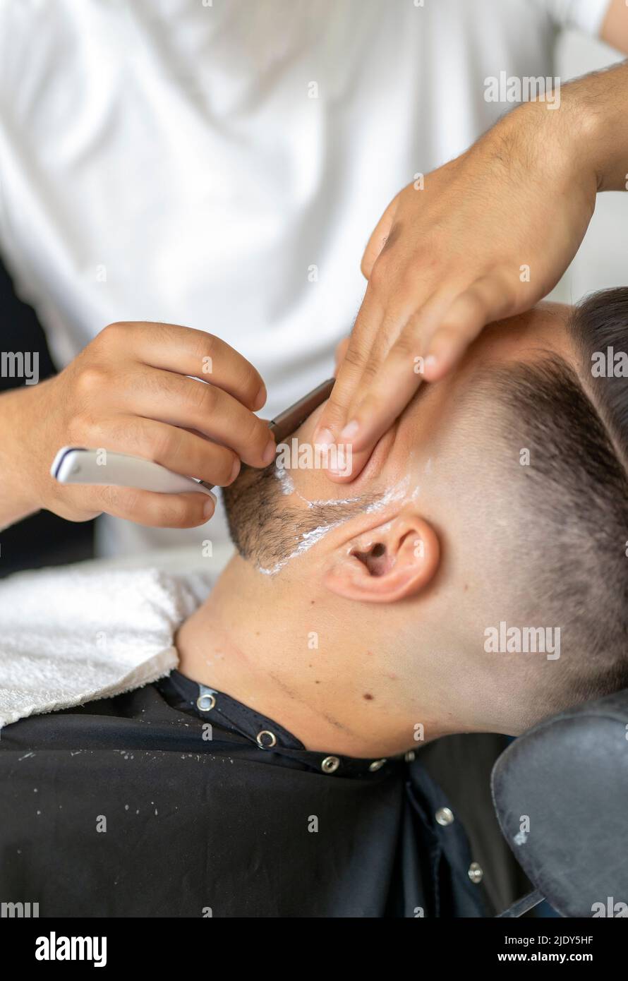 professional barber shaving a client Stock Photo
