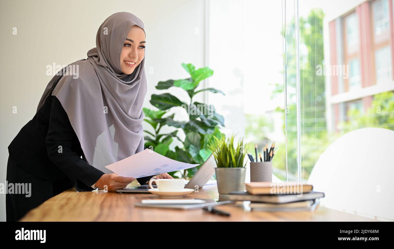 Successful and gorgeous asian muslim businesswoman with hijab working ...