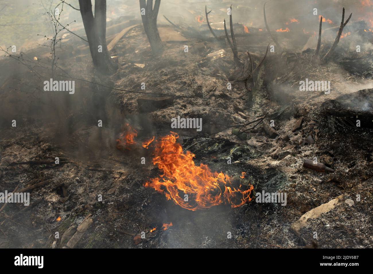 Burning of illegal landfill. Smoke and fire. Fire in street Stock Photo