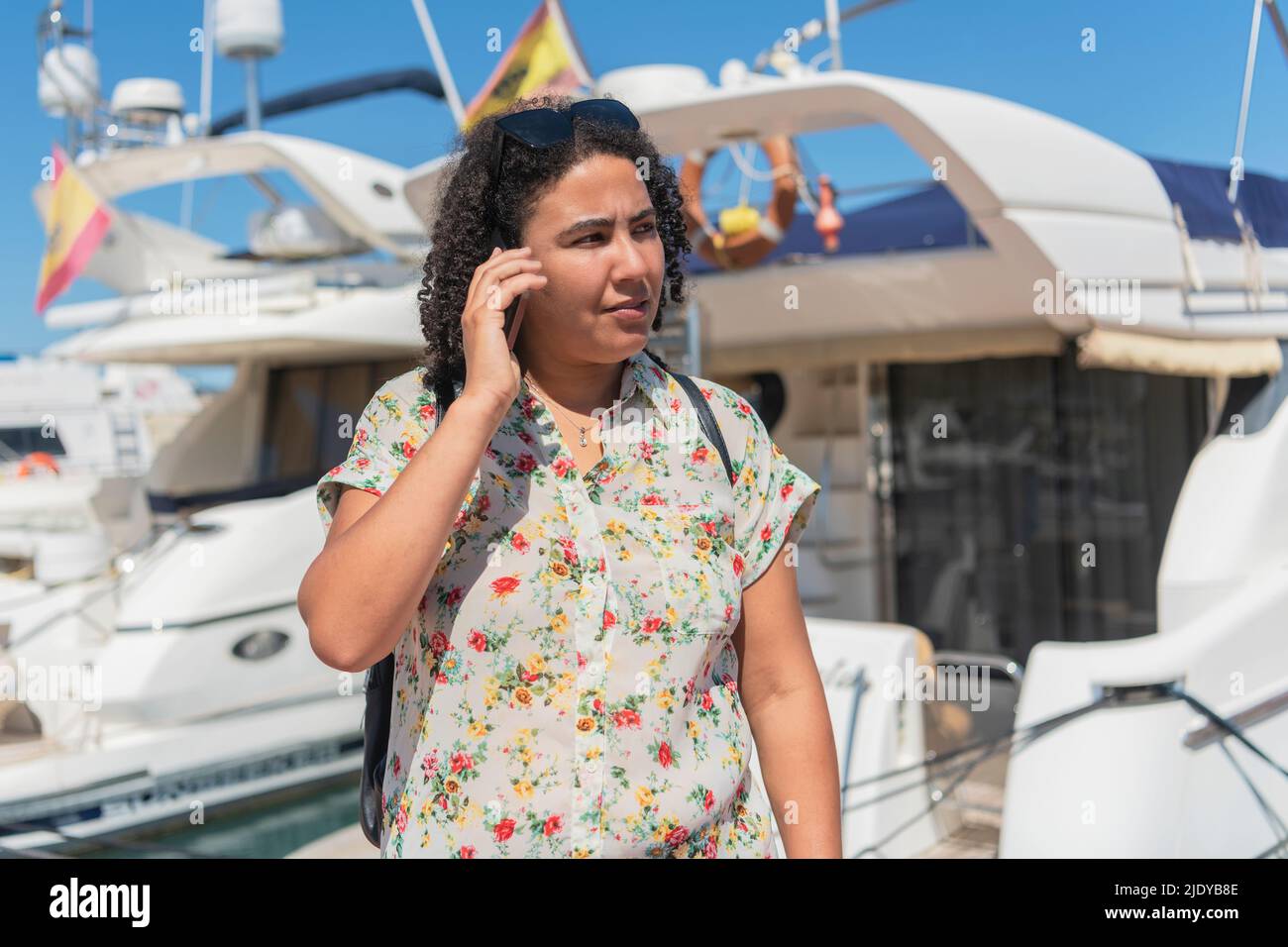 Woman talking on her phone near a boat. Selective focus. Holidays and technology concept. Stock Photo