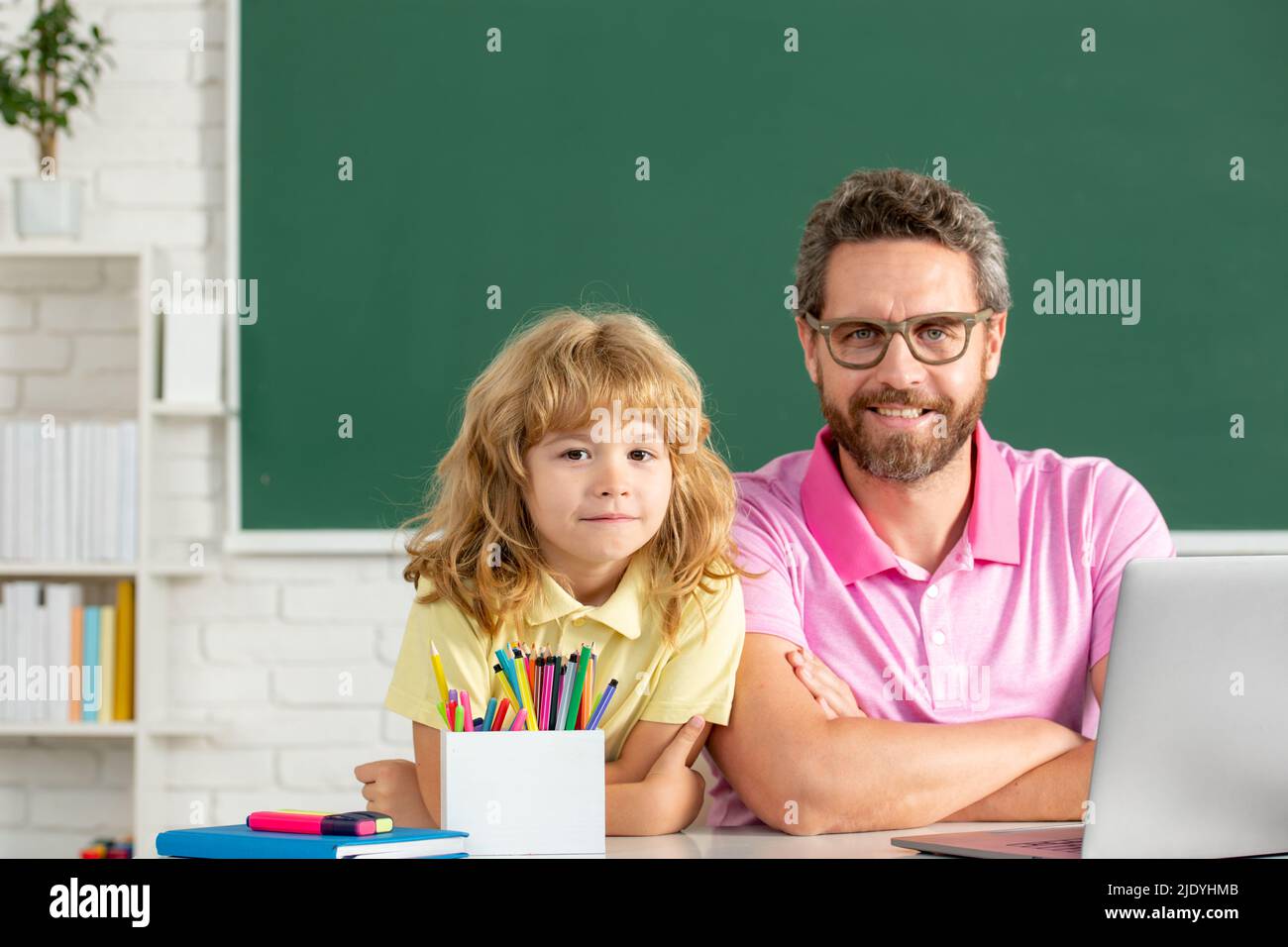 Teacher and schoolboy learning in class at school. Elementary school ...