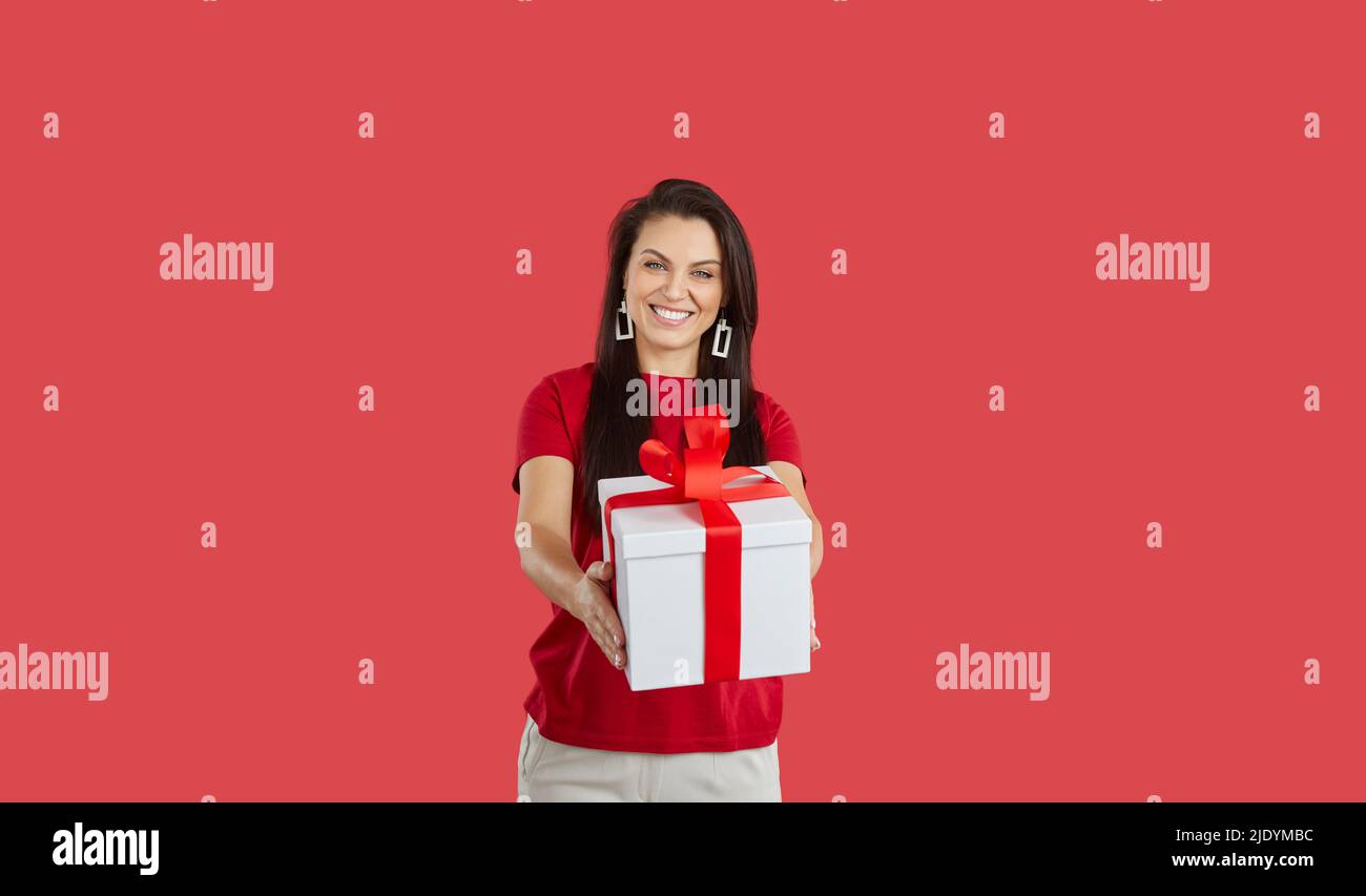 Smiling woman offer wrapped gift box Stock Photo