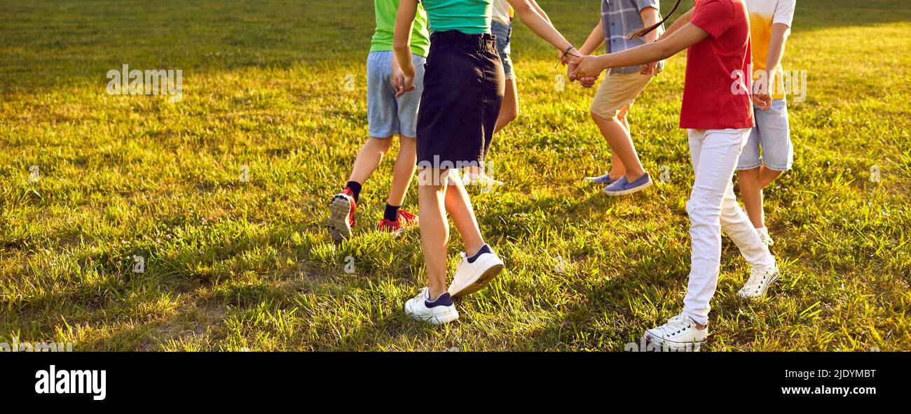 Group of little kids playing games, dancing in circle and having fun in