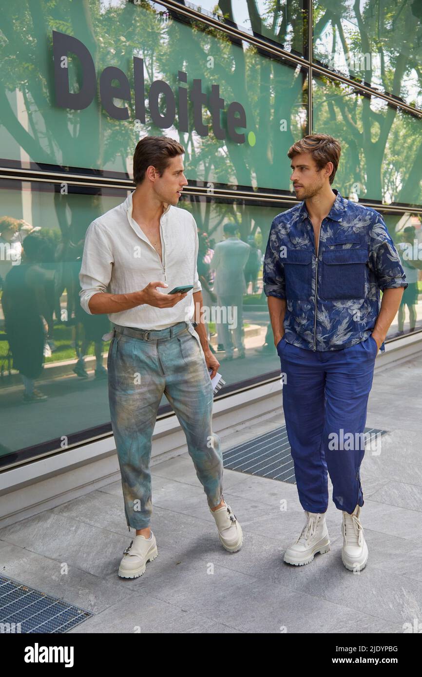 MILAN, ITALY - JUNE 18, 2022: Men with white shirt and blue trousers before Emporio Armani fashion show, Milan Fashion Week street style Stock Photo