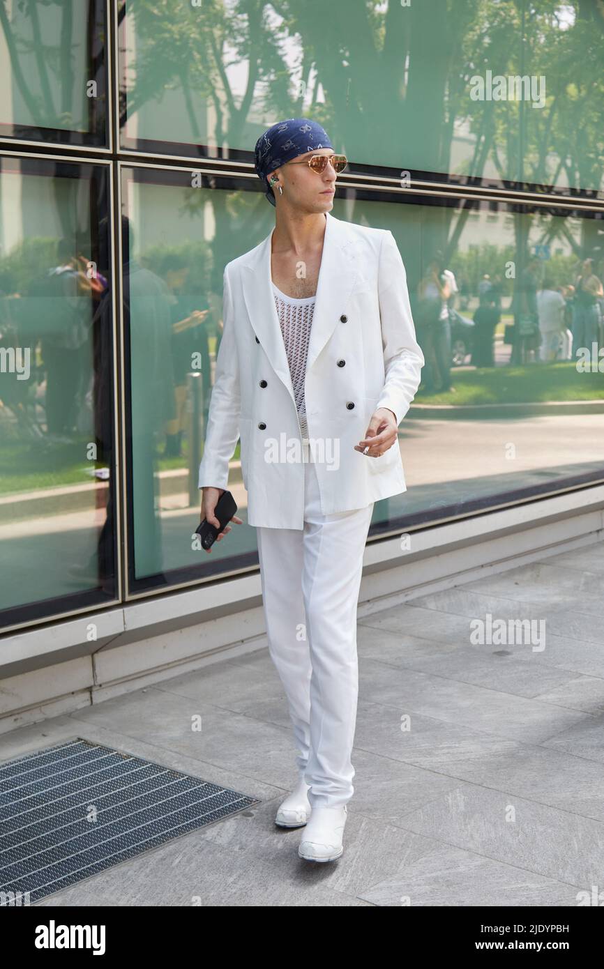 MILAN, ITALY - JUNE 18, 2022: Man with white jacket, trousers and shoes before Emporio Armani fashion show, Milan Fashion Week street style Stock Photo