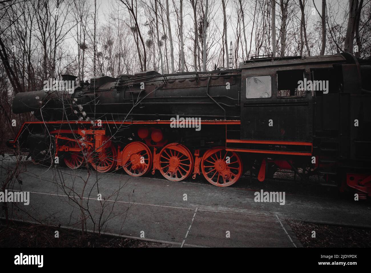 Steam locomotive parked at a terminal station. Historical railroad from 1940 in black red. Nostalgia photo of past technology Stock Photo