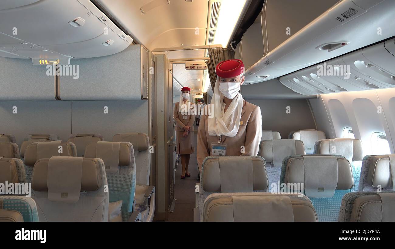 Flight attendants of Dubai's flagship airline Emirates wearing face mask stand aboard Boeing 777-300ER aircraft Stock Photo