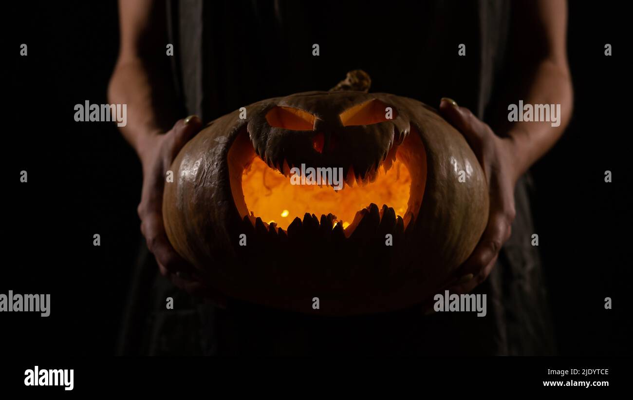 The witch is holding a pumpkin jack o lantern glowing in the dark ...