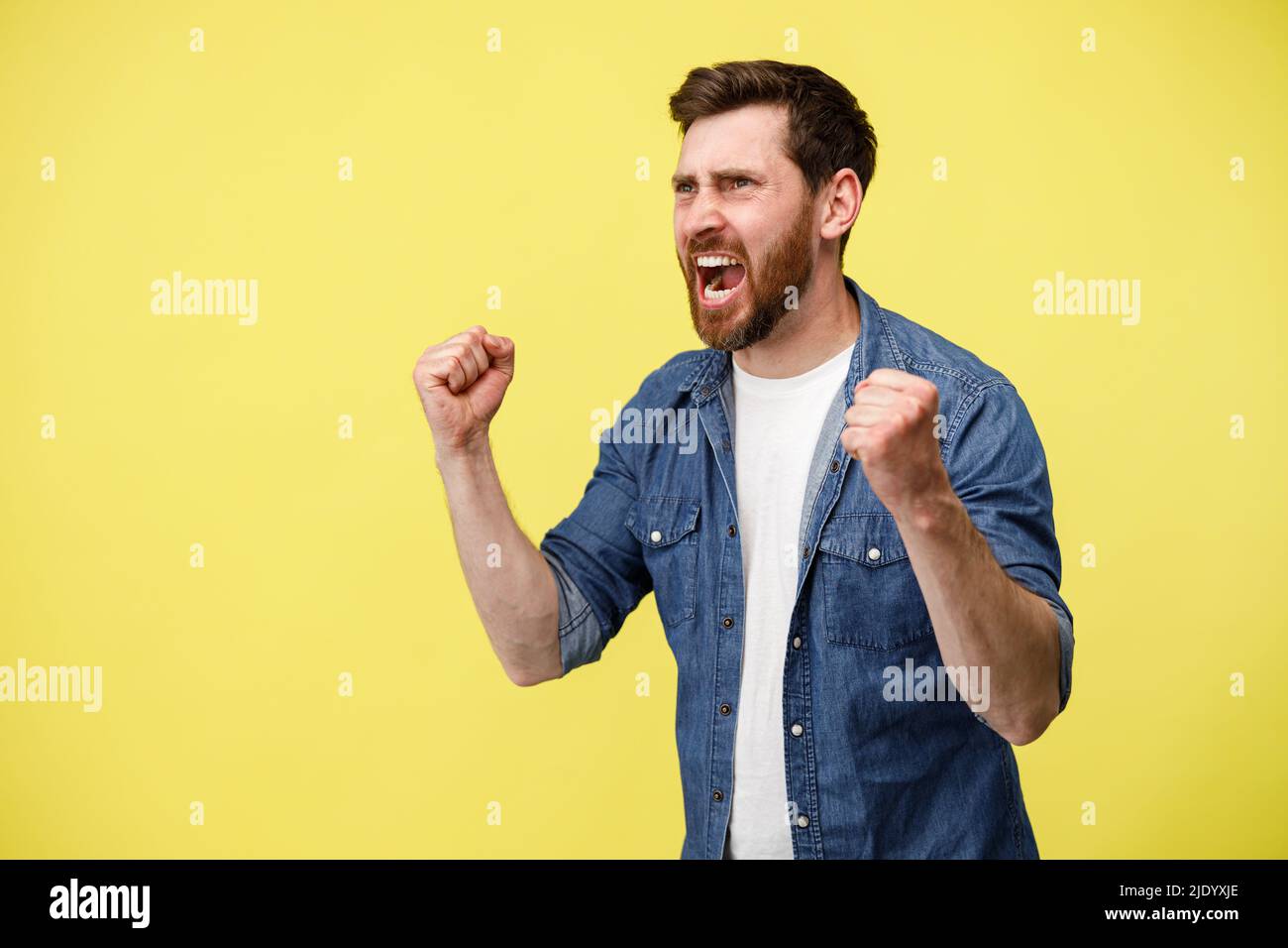 Male football fan screaming and doing winner gesture clenching fists