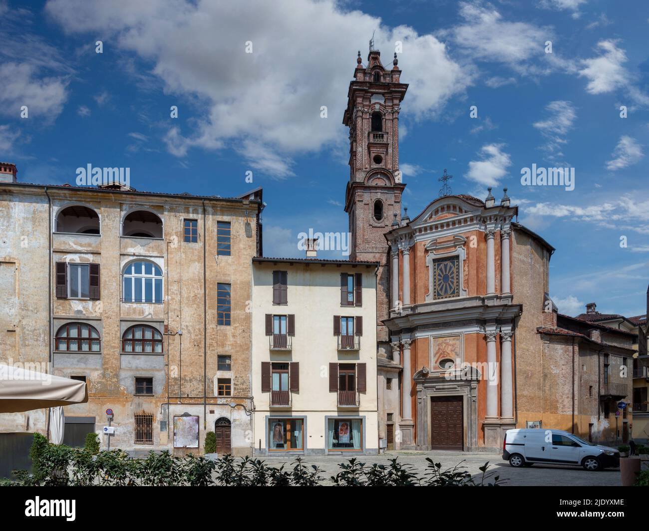 Savigliano, Cuneo, Piedmont, Italy - May 04, 2022: Church of the Confraternity of the Pietà with ancient buildings in Cesare Battisti square on blue s Stock Photo