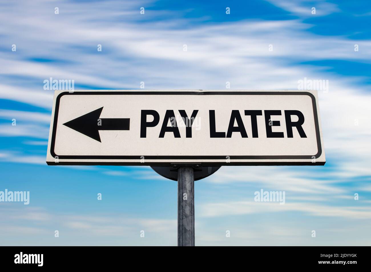 Pay later road sign, arrow on blue sky background. One way blank road sign with copy space. Arrow on a pole pointing in one direction. Stock Photo
