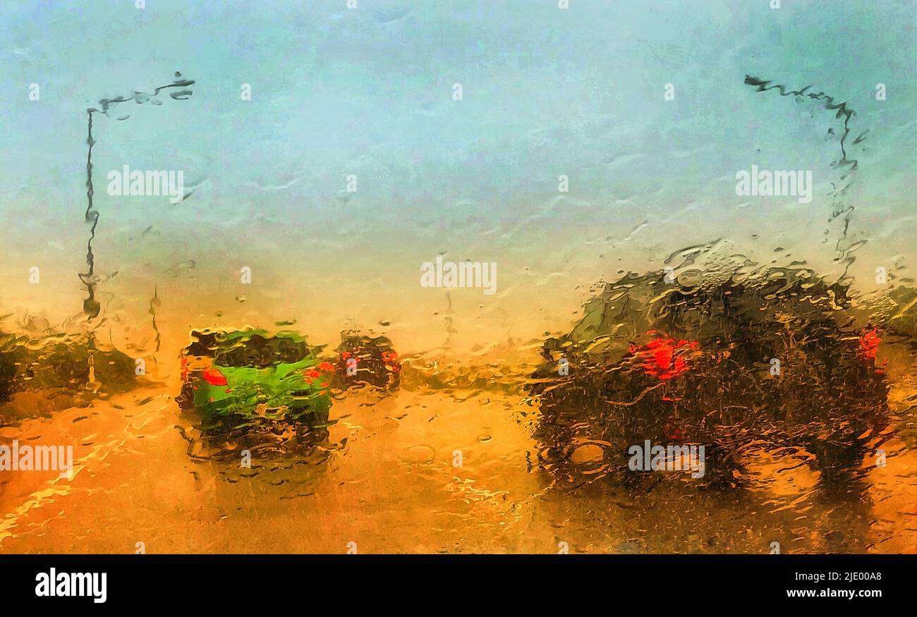 Cars travelling on highway in the heavy rain. Photo taken through a rain spattered car window. Stock Photo