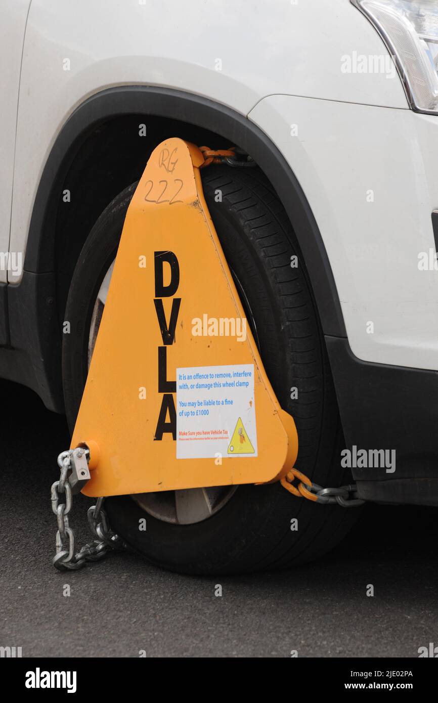 uninsured or untaxed vehicle clamped by roadside Stock Photo