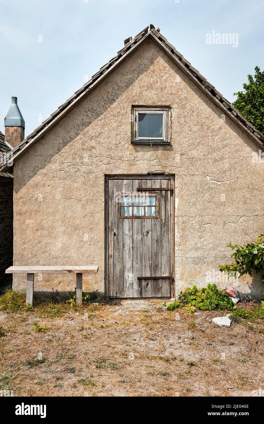 Old stone fisherman's hut with wooden door and bench, fishing spot, seasonal coastal village, Norebod Fiskelaege, Southern Gotland, Gotland Island Stock Photo