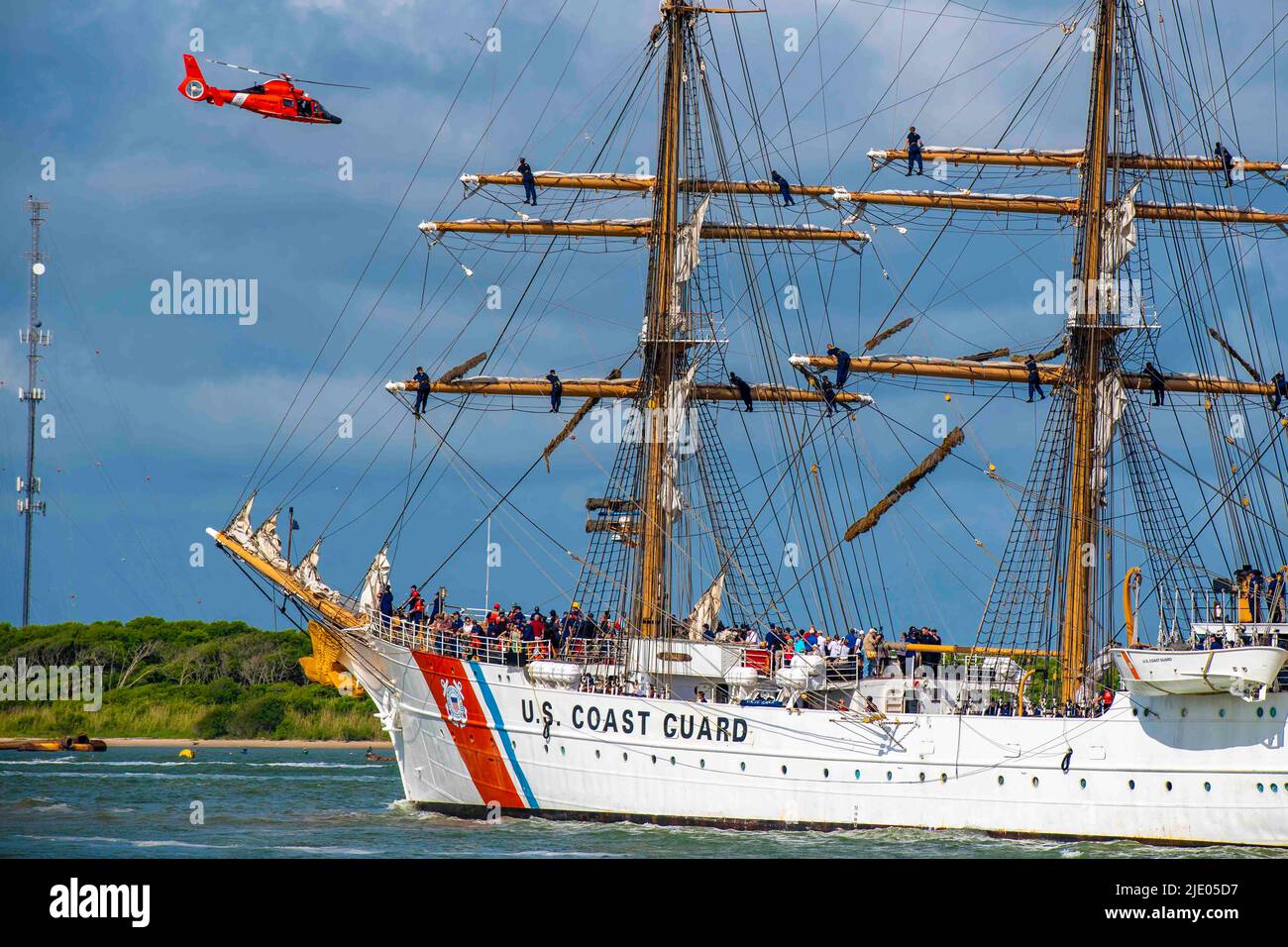 Galveston, Texas, USA. 10th June, 2022. A Coast Guard Air Station Houston MH-65 Dolphin helicopter flies over the U.S. Coast Guard Cutter Barque Eagle as it transits the Galveston Channel towards Pier 21 in Galveston, Texas, June 10, 2022. Homeported at the Coast Guard Academy in New London, Conn., the Eagle is used as a training platform for future Coast Guard officers and visited Galveston, Texas, for the first time since 1972. Credit: U.S. Coast Guard/ZUMA Press Wire Service/ZUMAPRESS.com/Alamy Live News Stock Photo
