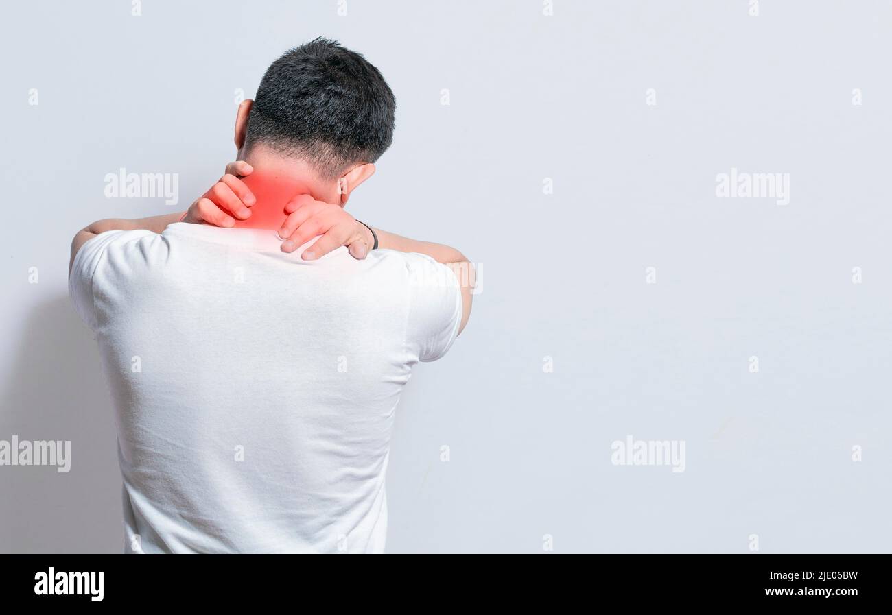 Close up of person with shoulder and neck problems, sore man touching his shoulder on isolated background, lumbar and muscular problems concept Stock Photo