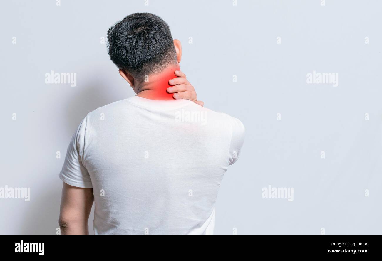 Close up of person with shoulder and neck problems, sore man touching his shoulder on isolated background, lumbar and muscular problems concept Stock Photo