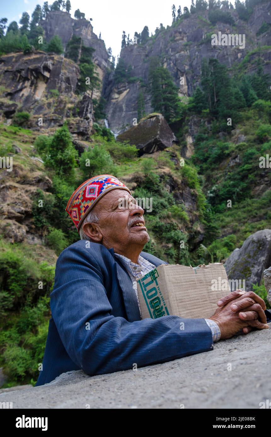 local Himalayan old man with traditional cap, against mountains Stock Photo