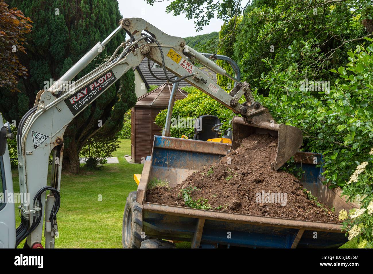 Excavator working in a large garden, in Devon. Stock Photo