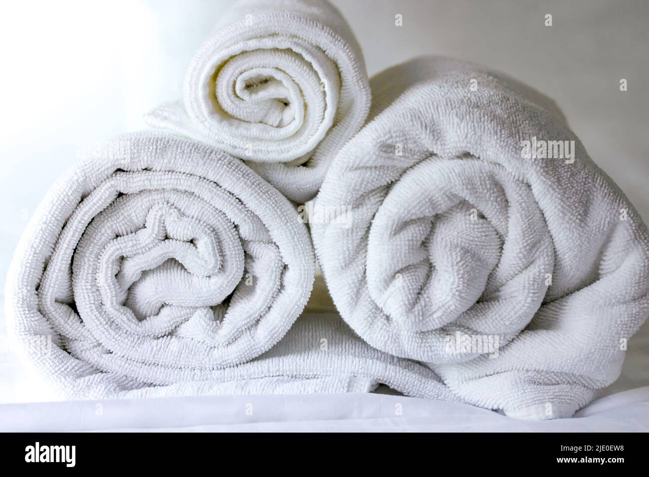 https://c8.alamy.com/comp/2JE0EW8/white-towel-roll-on-bed-in-hotelclose-up-2JE0EW8.jpg