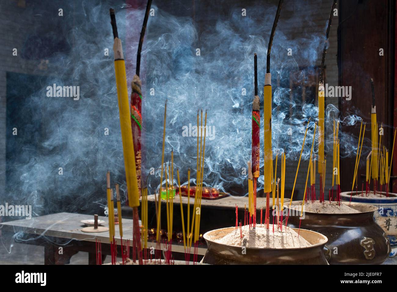 Incense sticks burning on incense pot, smoke used to pay respect to the