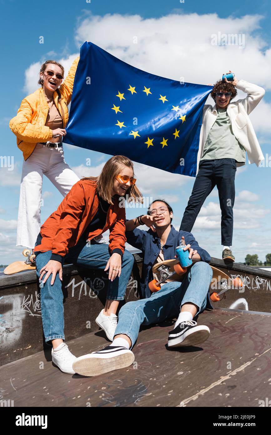 cheerful multiethnic friends with flag of european union in skate park Stock Photo