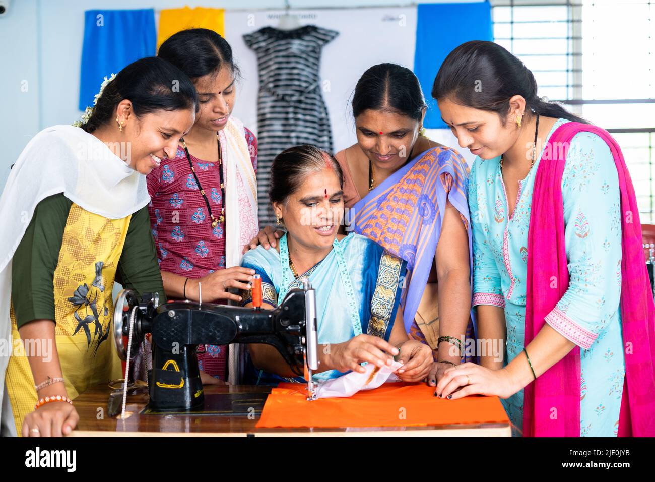 group of woman at tailoring class discuissing with teacher about cloth and stitching during training - concept of skill development and vocational Stock Photo