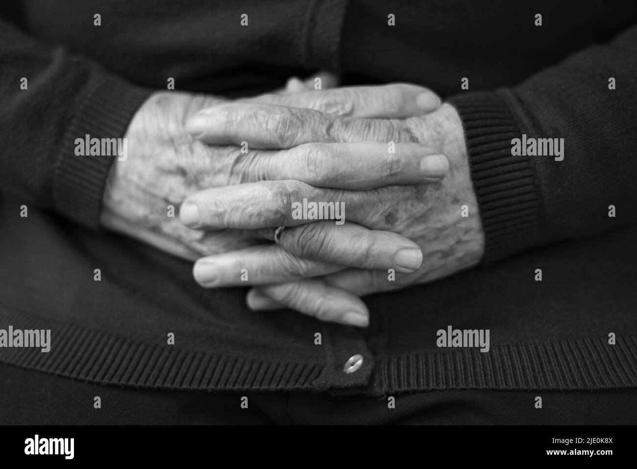 Senior woman hands with crossed fingers, black and white photo. Stock Photo