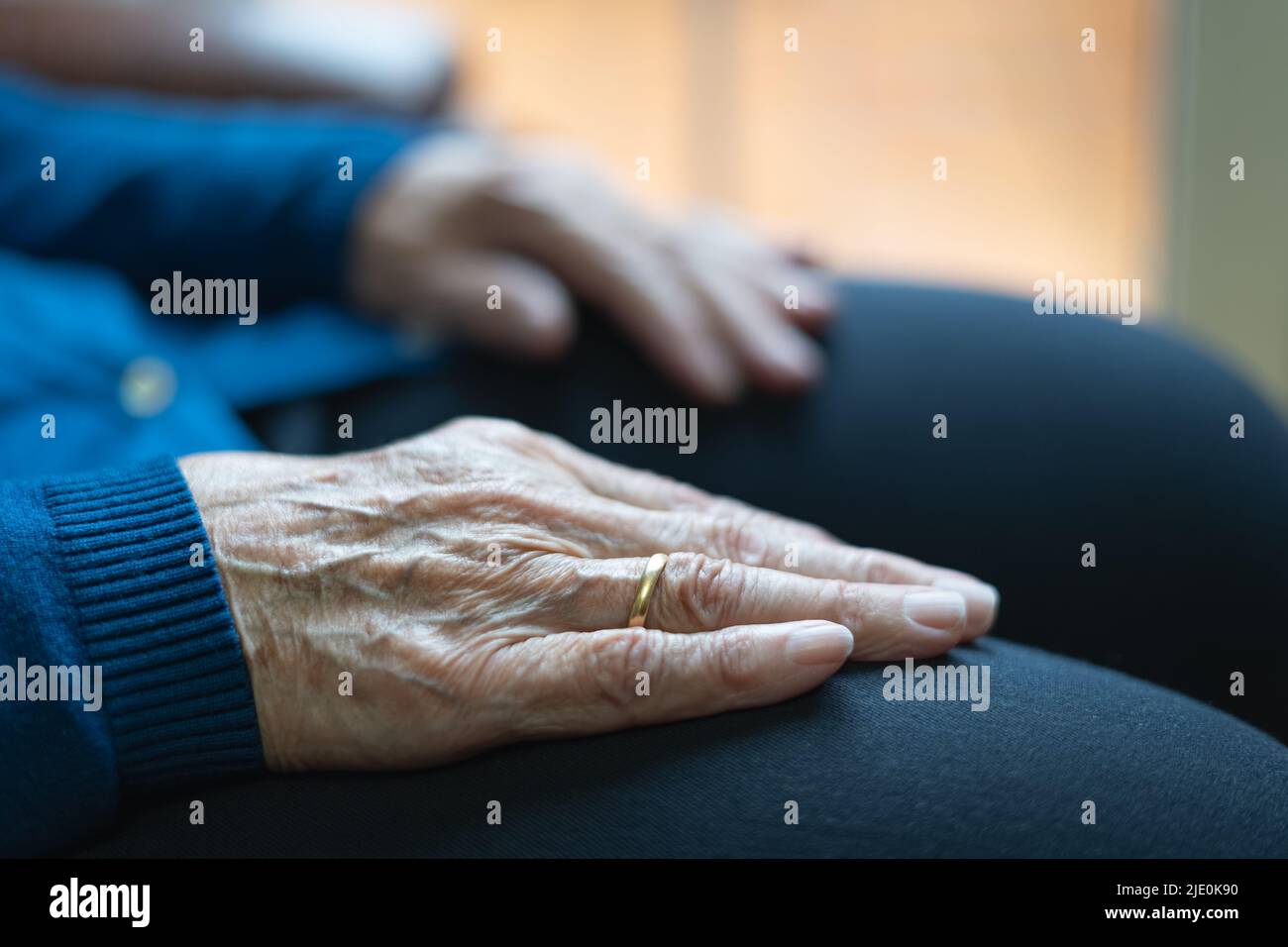 Older woman's hands resting on her legs in an attitude of rest and